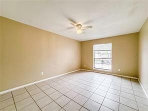 unfurnished room featuring baseboards, light tile patterned floors, and a ceiling fan
