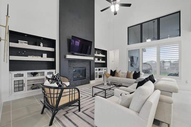 21134 Coral View Dr, Cypress, TX 77433 - tiled living room with ceiling fan, built in features, a towering ceiling, and a fireplace