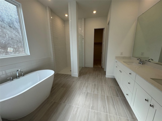 31319 Hastings Creek Ln, Fulshear, TX 77441 - bathroom with tiled shower, double vanity, a freestanding tub, recessed lighting, and tile patterned floors