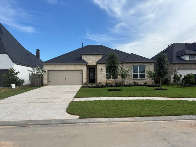 31319 Hastings Creek Ln, Fulshear, TX 77441 - french provincial home with a front yard, concrete driveway, an attached garage, and stone siding