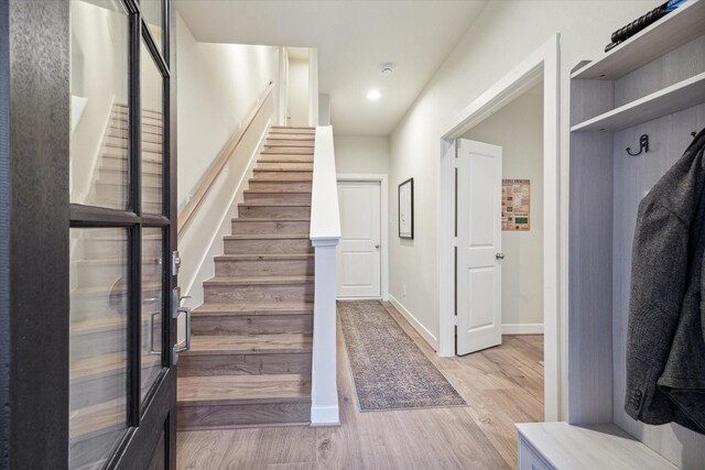 stairs featuring baseboards, wood finished floors, and recessed lighting