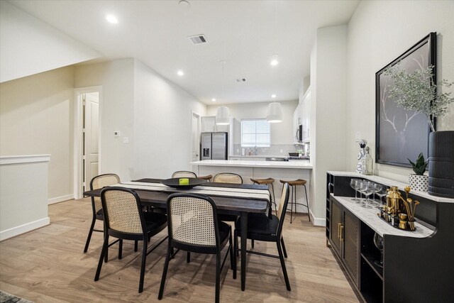 dining space featuring visible vents, baseboards, and light wood-type flooring