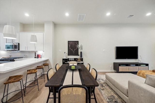 dining space featuring visible vents, light wood-style flooring, and recessed lighting