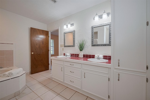 26003 Fountaine Bleau Dr, Tomball, TX 77377 - bathroom with double vanity, a bath, tile patterned flooring, and a textured ceiling