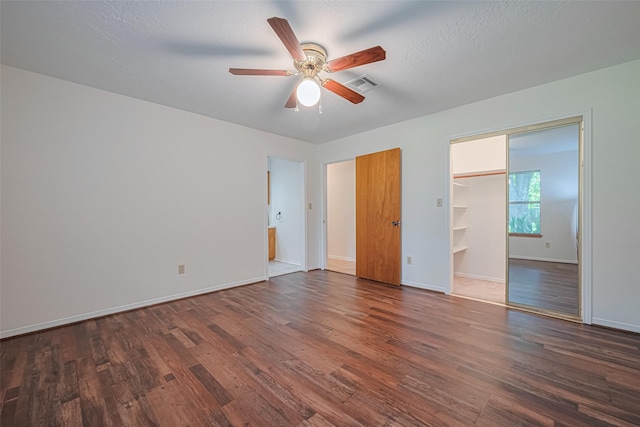 26003 Fountaine Bleau Dr, Tomball, TX 77377 - unfurnished bedroom with wood finished floors, baseboards, a walk in closet, and ensuite bath