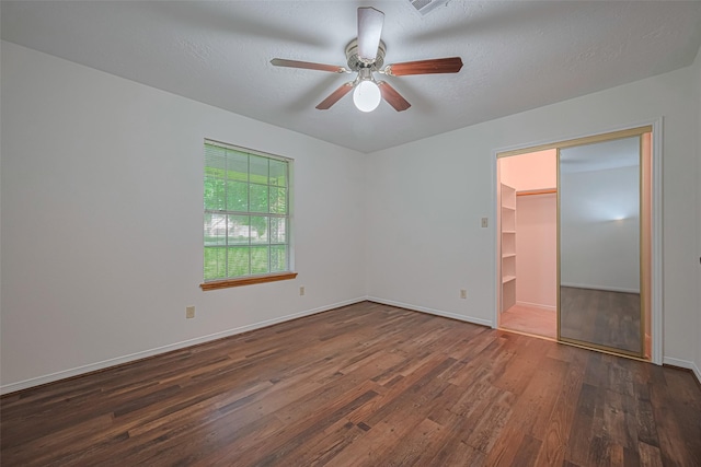 26003 Fountaine Bleau Dr, Tomball, TX 77377 - unfurnished bedroom with wood finished floors, baseboards, a spacious closet, ceiling fan, and a closet