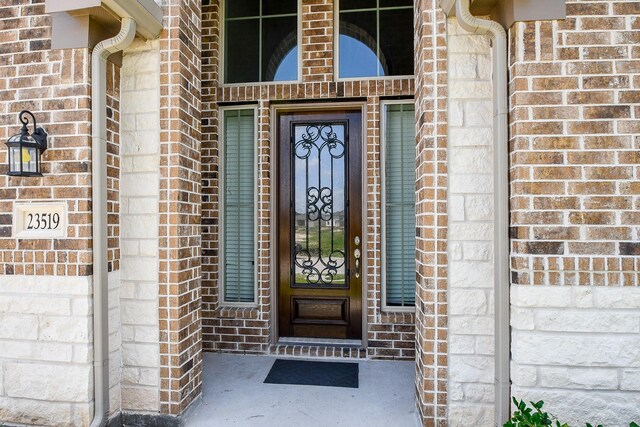 property entrance featuring brick siding