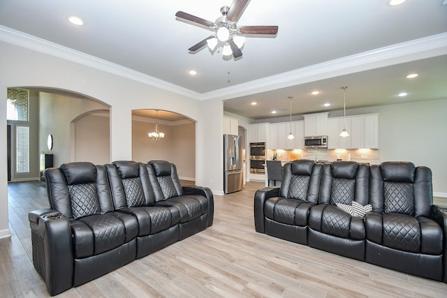 living room with arched walkways, crown molding, a ceiling fan, and recessed lighting