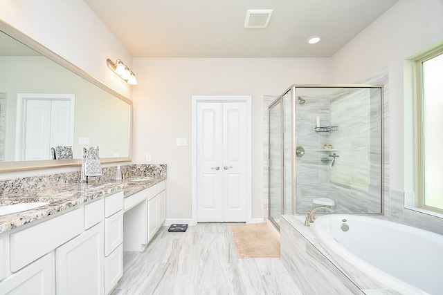 bathroom with a shower stall, a sink, and visible vents