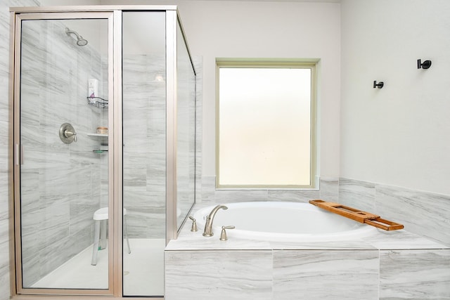 full bathroom featuring a bath and a shower stall