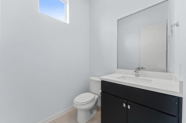 bathroom with baseboards, toilet, tile patterned flooring, and vanity