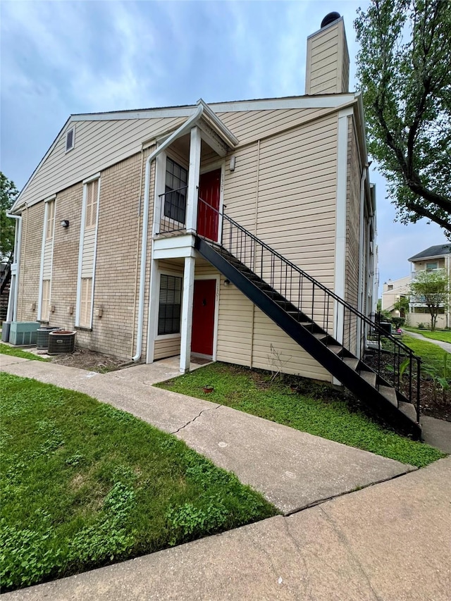 2750 Holly Hall St Unit 1301, Houston, TX 77054 - view of front facade with stairway, a chimney, and a front yard