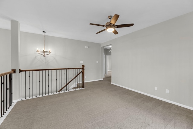 empty room featuring baseboards, carpet floors, and ceiling fan with notable chandelier