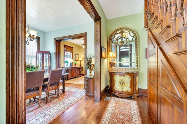 hallway featuring hardwood / wood-style flooring and baseboards