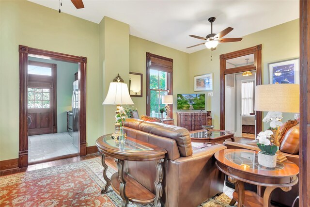 living room featuring baseboards, wood finished floors, and ceiling fan