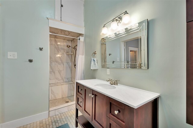 bathroom featuring vanity, baseboards, and a tile shower