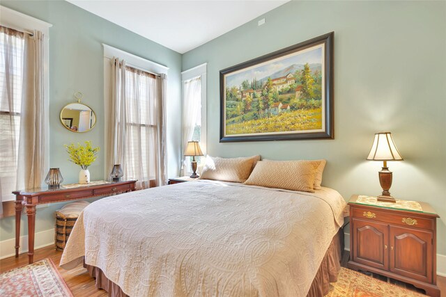 bedroom with baseboards and light wood-type flooring