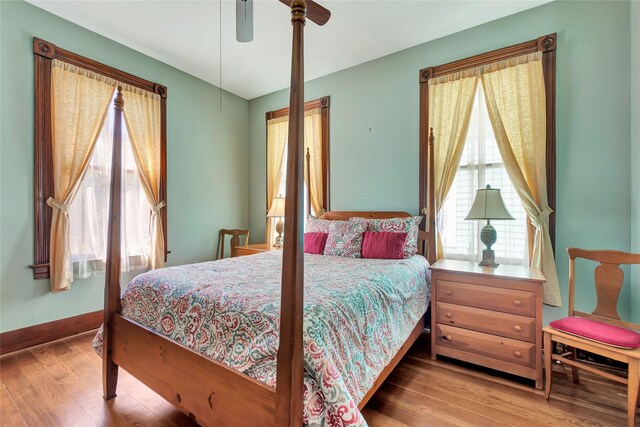 bedroom with baseboards, ceiling fan, and wood finished floors