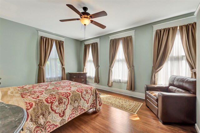 bedroom featuring baseboards, ceiling fan, and wood finished floors