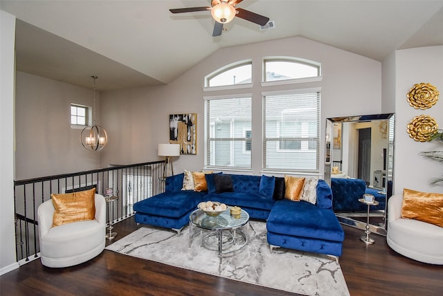 living area featuring visible vents, ceiling fan with notable chandelier, vaulted ceiling, and wood finished floors