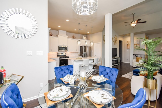 dining space featuring recessed lighting, ceiling fan with notable chandelier, baseboards, and dark wood finished floors