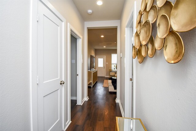 hall featuring dark wood-style flooring, baseboards, and recessed lighting