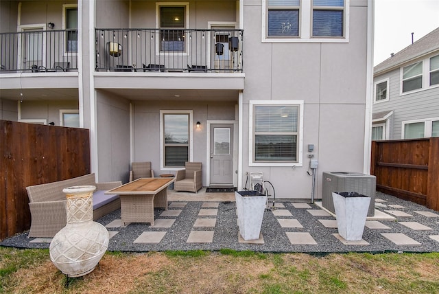 rear view of house featuring central air condition unit, stucco siding, and a patio