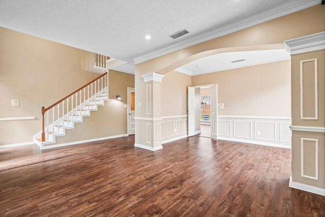 unfurnished room featuring arched walkways, stairs, wood finished floors, visible vents, and ornamental molding
