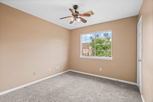 carpeted empty room featuring baseboards and a ceiling fan