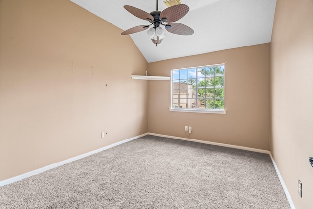 carpeted empty room with a ceiling fan, baseboards, and vaulted ceiling