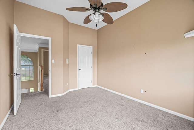 unfurnished bedroom with carpet flooring, a ceiling fan, baseboards, and high vaulted ceiling