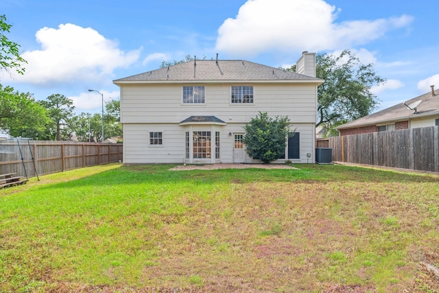 rear view of house with a lawn, a fenced backyard, and a chimney