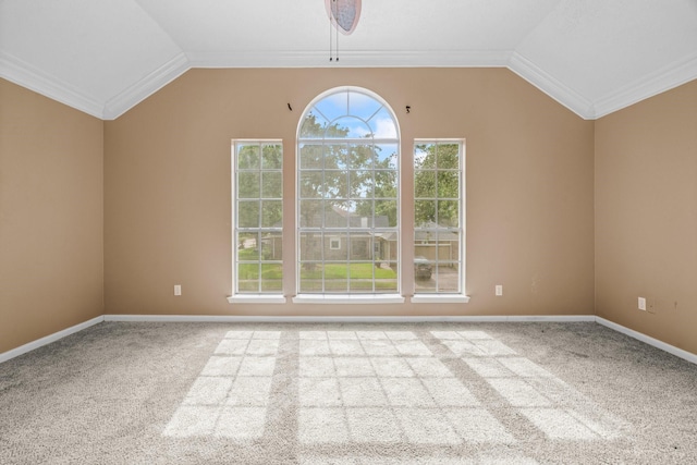 carpeted empty room featuring baseboards, ornamental molding, and vaulted ceiling