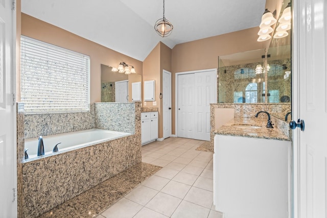 bathroom featuring a bath, tile patterned flooring, a shower stall, two vanities, and a sink
