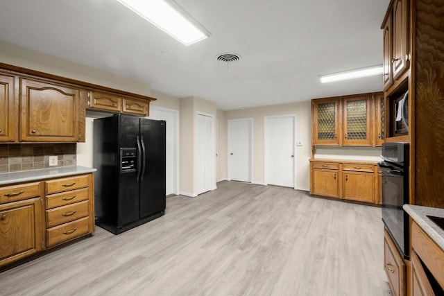 kitchen with visible vents, light countertops, black appliances, and light wood-style floors