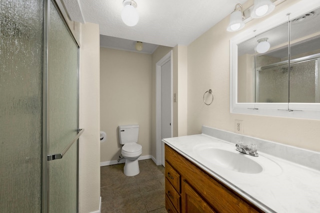 bathroom featuring baseboards, toilet, vanity, a stall shower, and tile patterned flooring