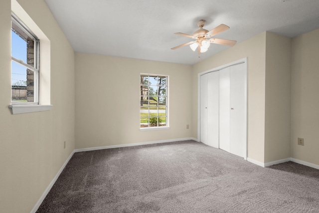 unfurnished bedroom with a closet, carpet, baseboards, and ceiling fan