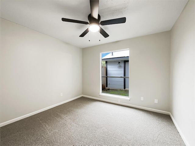 carpeted spare room with baseboards and ceiling fan