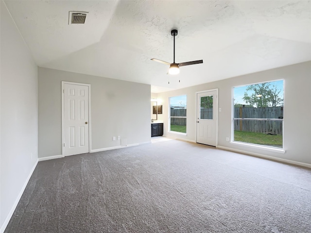 unfurnished living room with baseboards, visible vents, ceiling fan, and carpet flooring