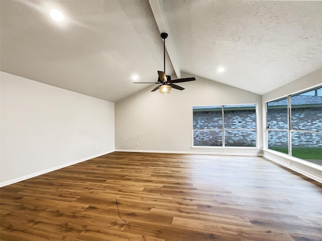 empty room featuring a ceiling fan, vaulted ceiling with beams, wood finished floors, a textured ceiling, and baseboards