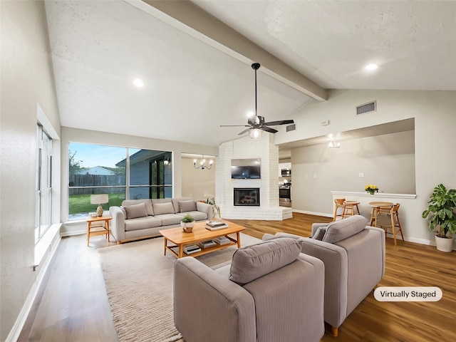 living area with lofted ceiling with beams, baseboards, visible vents, ceiling fan, and wood finished floors