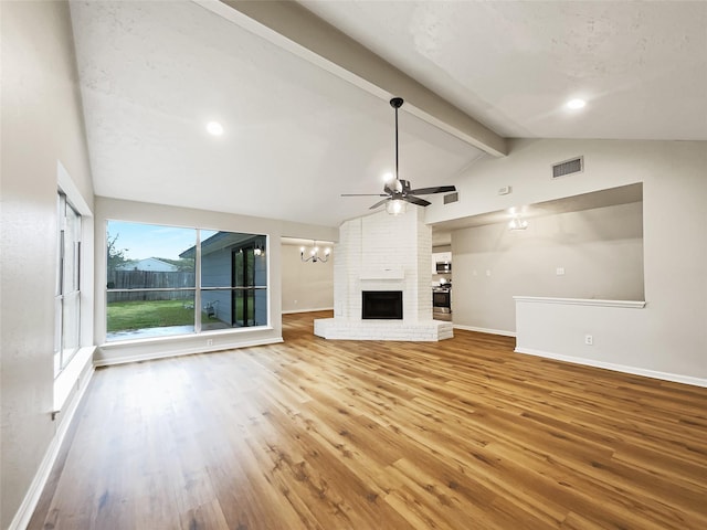 unfurnished living room featuring lofted ceiling with beams, baseboards, visible vents, and wood finished floors