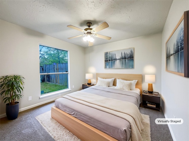 carpeted bedroom featuring baseboards, ceiling fan, and a textured ceiling