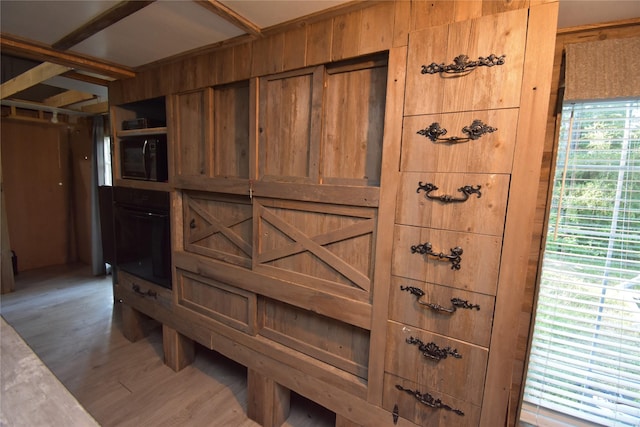 interior details featuring black oven and wood finished floors