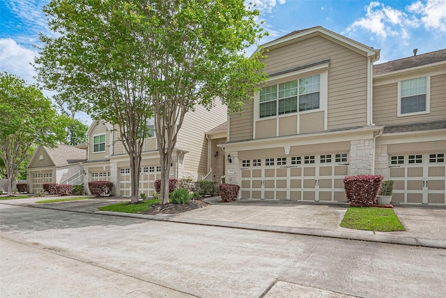 13600 Breton Ridge St Unit 22D, Houston, TX 77070 - view of front of property featuring stone siding, a garage, and concrete driveway