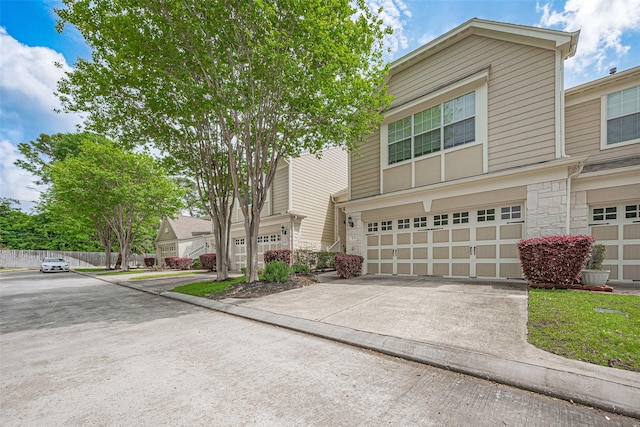 13600 Breton Ridge St Unit 22D, Houston, TX 77070 - view of front facade with stone siding, an attached garage, and concrete driveway