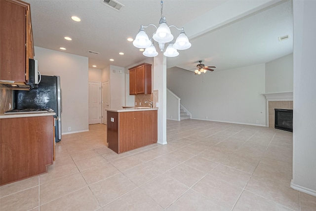 13600 Breton Ridge St Unit 22D, Houston, TX 77070 - kitchen featuring open floor plan, brown cabinetry, decorative backsplash, a chandelier, and light tile patterned flooring