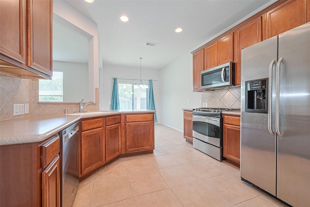 13600 Breton Ridge St Unit 22D, Houston, TX 77070 - kitchen featuring appliances with stainless steel finishes, a sink, brown cabinets, light countertops, and recessed lighting