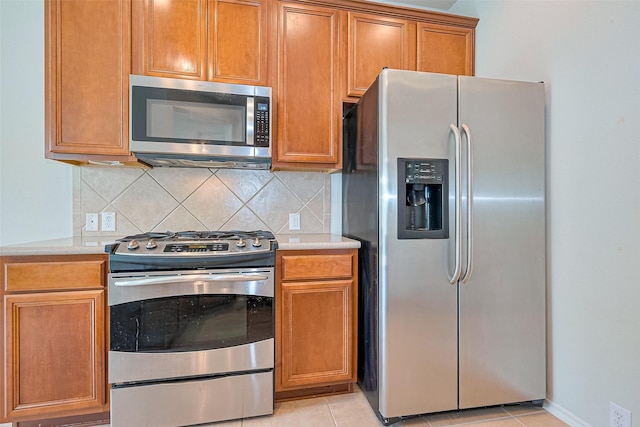 13600 Breton Ridge St Unit 22D, Houston, TX 77070 - kitchen with appliances with stainless steel finishes, light countertops, backsplash, and light tile patterned floors