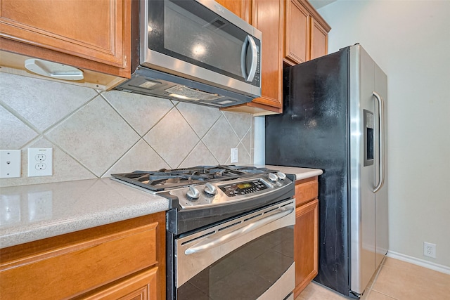 13600 Breton Ridge St Unit 22D, Houston, TX 77070 - kitchen with stainless steel appliances, tasteful backsplash, light countertops, and brown cabinets